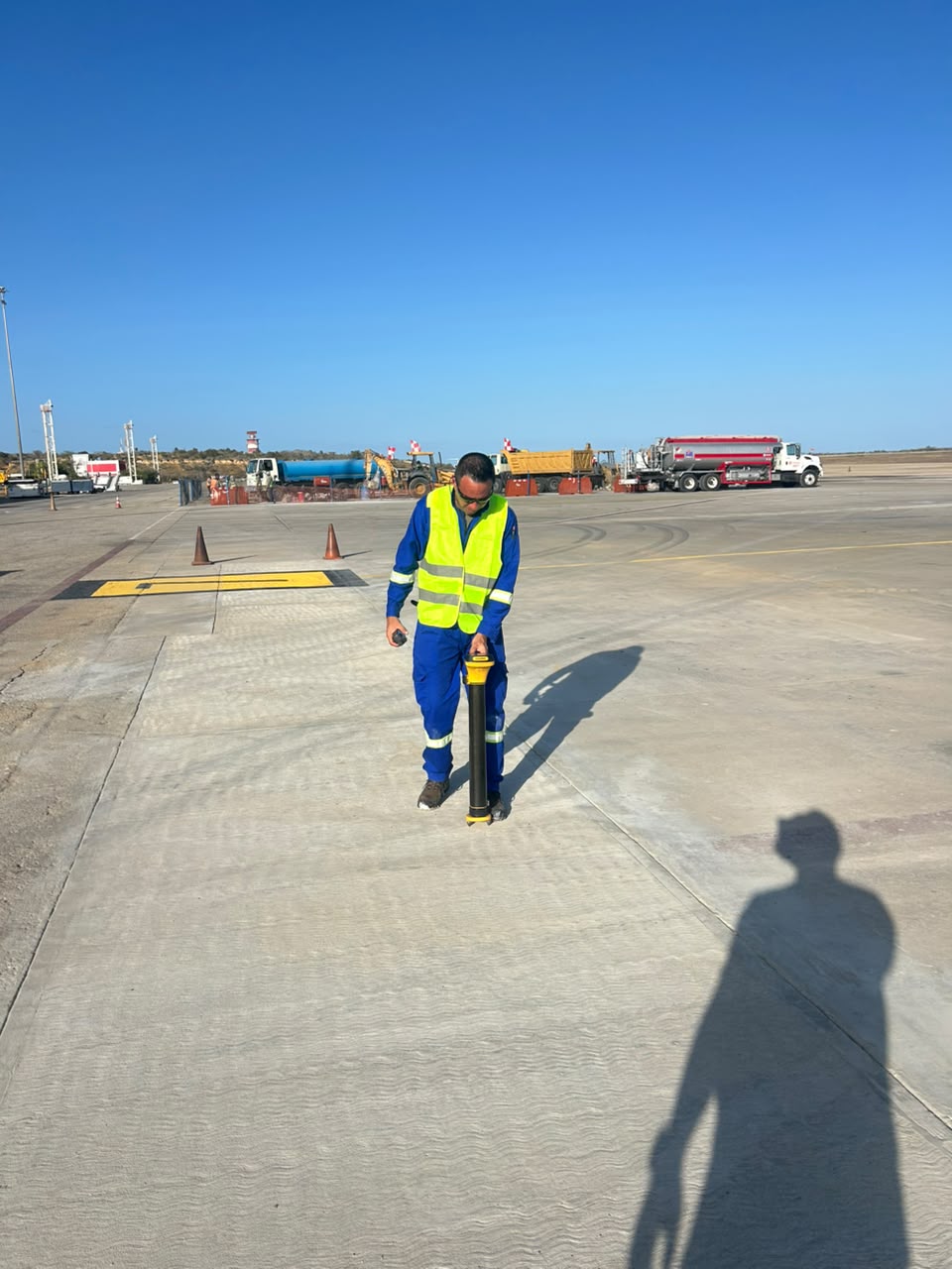 Operador con chaleco reflectante y equipo de detección en campo.